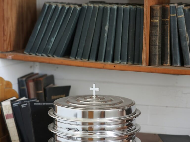 Silver communion trays sit near old books.